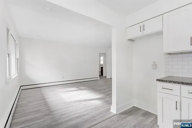 an empty room with wooden floor and cabinet
