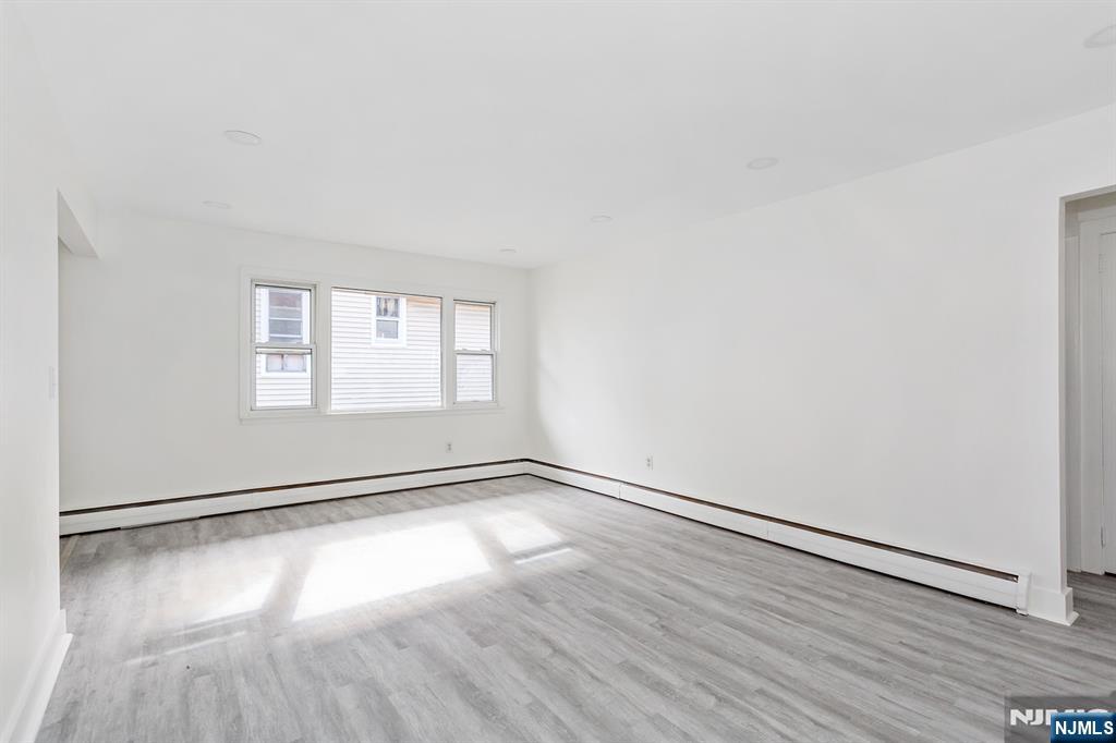 86 Chestnut Street, Unit 2 Rutherford, NJ 07070 - Photo 12 of 20 an empty room with wooden floor and windows