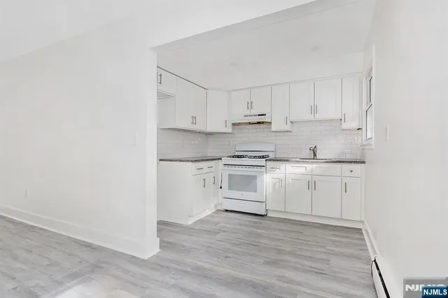 a kitchen with white cabinets and white appliances