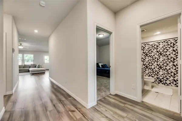 a view of a hallway view with wooden floor and living room