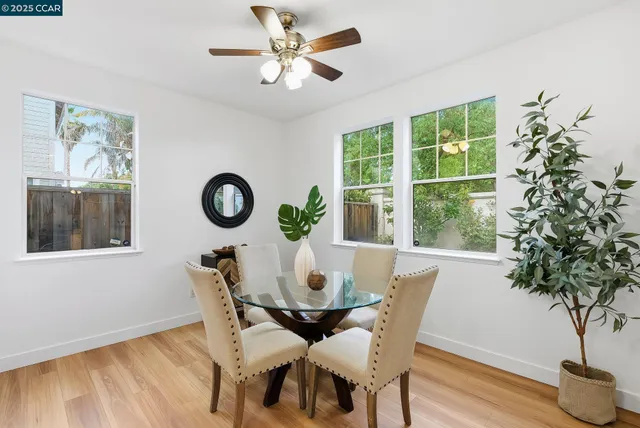 a dining room with furniture potted plants and wooden floor