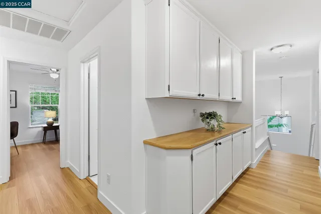 a kitchen that has a lot of cabinets in it with wooden floor