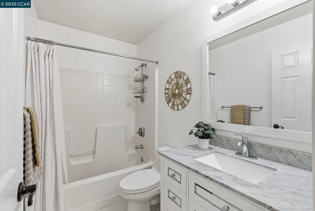 a bathroom with a granite countertop sink toilet a mirror a vanity and shower