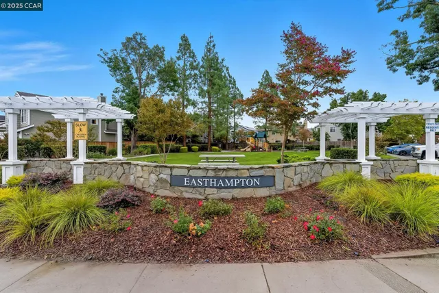 a view of a house with a garden and sitting area
