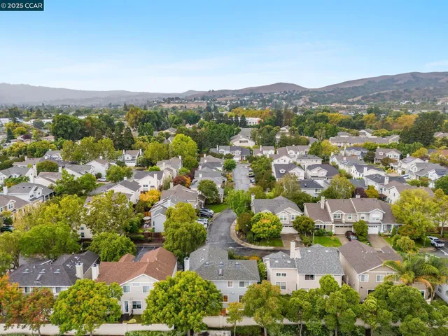 an aerial view of residential houses with outdoor space and trees