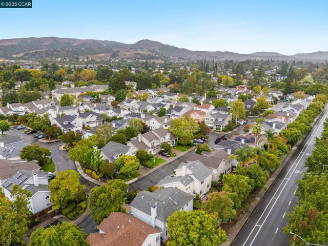 an aerial view of a city with lots of residential buildings and mountain view in back