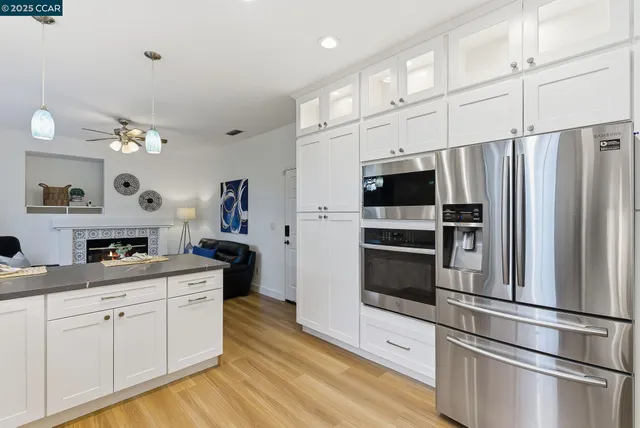 a kitchen with stainless steel appliances a refrigerator stove and white cabinets