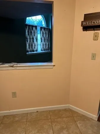 a view of a small space with wooden floor and a window