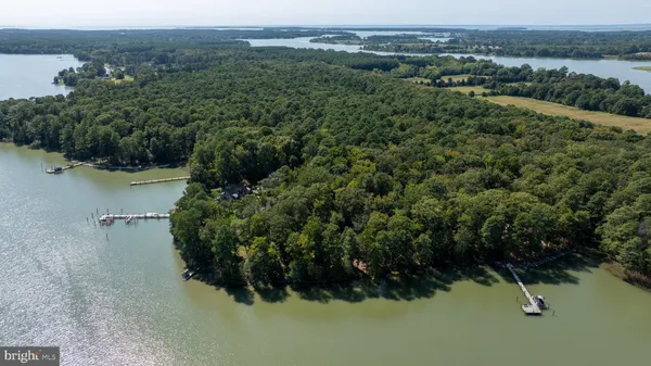 an aerial view of residential house with outdoor space and trees all around