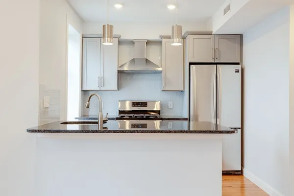 a kitchen with stainless steel appliances a refrigerator and a stove top oven