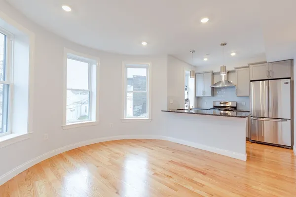 a kitchen with stainless steel appliances granite countertop a refrigerator a sink a stove a microwave and white cabinets