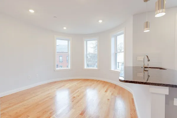 a view of a kitchen with wooden floor and a window