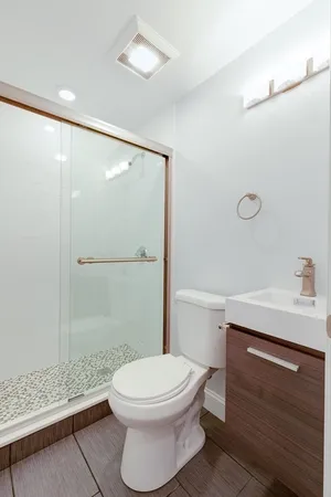 a bathroom with a sink a toilet and shower