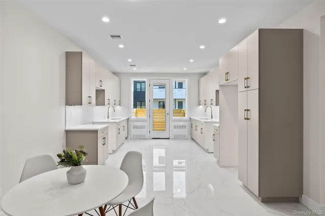 a large white kitchen with a white table and chairs