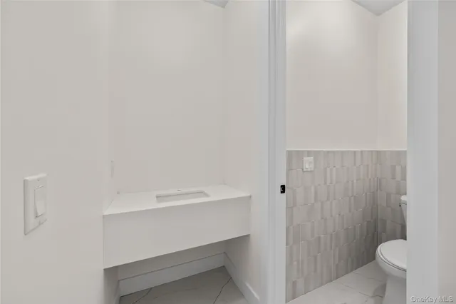a white toilet sitting next to a shower