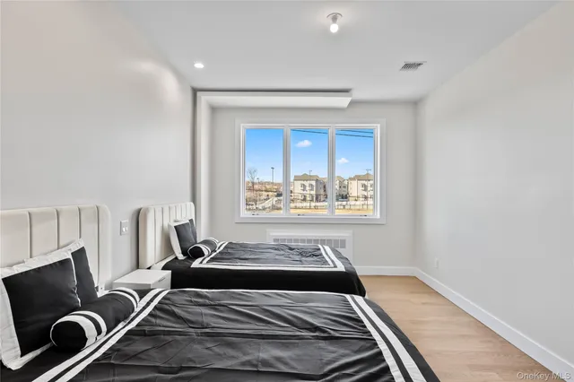 a bedroom with two beds and a lamp