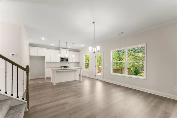 a large kitchen with stainless steel appliances granite countertop a stove a refrigerator a sink and a fireplace with wooden floor