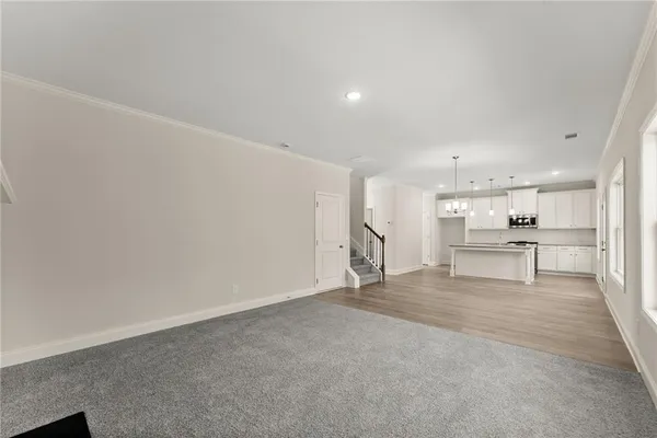 a view of kitchen with refrigerator and white cabinets