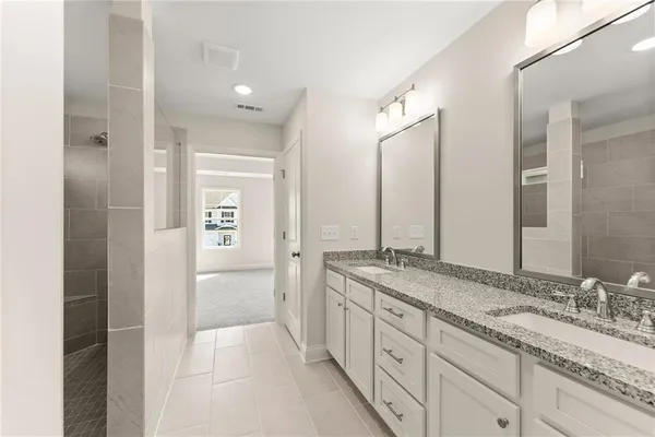 a spacious bathroom with a granite countertop sink mirror and double