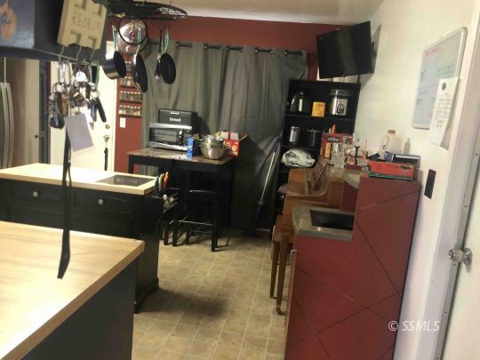 125 South Broadway Street Ridgecrest, CA 93555 - Photo 7 of 24 a kitchen with a refrigerator and a table