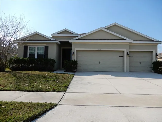a front view of a house with a garden and garage