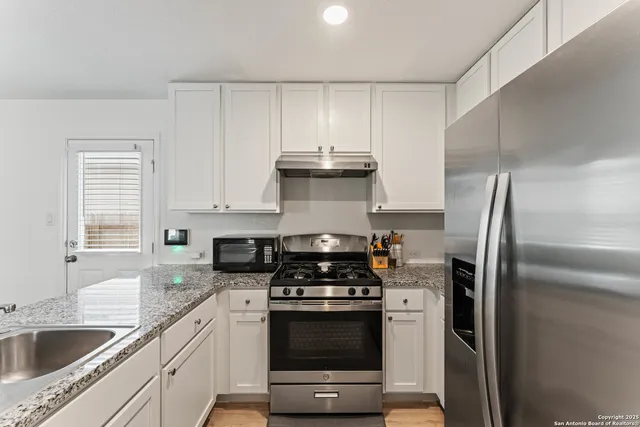 a kitchen with stainless steel appliances granite countertop a sink stove and refrigerator