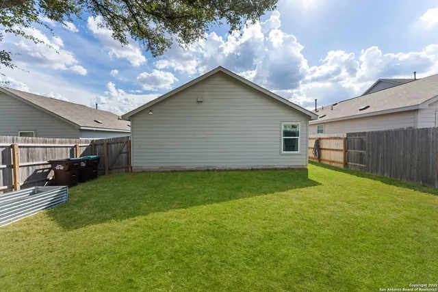 a view of backyard of house and car parked