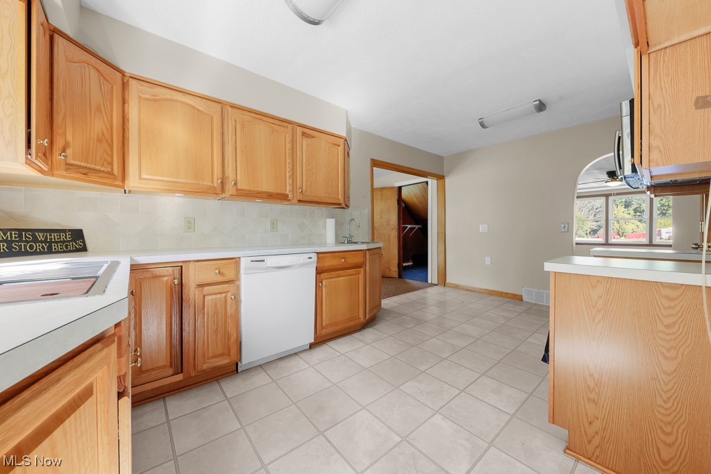 1702 Far View Road Akron, OH 44312 - Photo 13 of 49 Kitchen with light countertops, decorative backsplash, dishwasher, and light tile patterned floors
