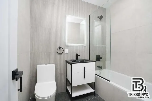 a white toilet sitting next to a bathroom sink