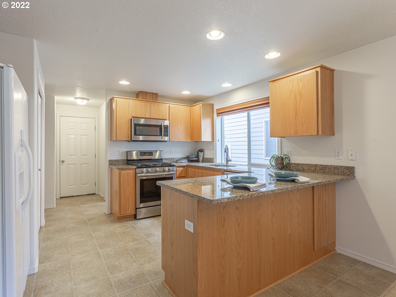 3206 South 2nd Way Ridgefield, WA 98642 - Photo 11 of 32 a kitchen with stainless steel appliances granite countertop a sink a stove and a refrigerator