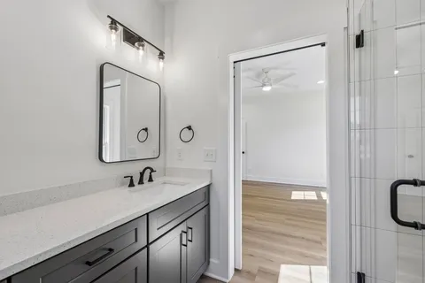 a bathroom with a sink toilet a mirror and shower