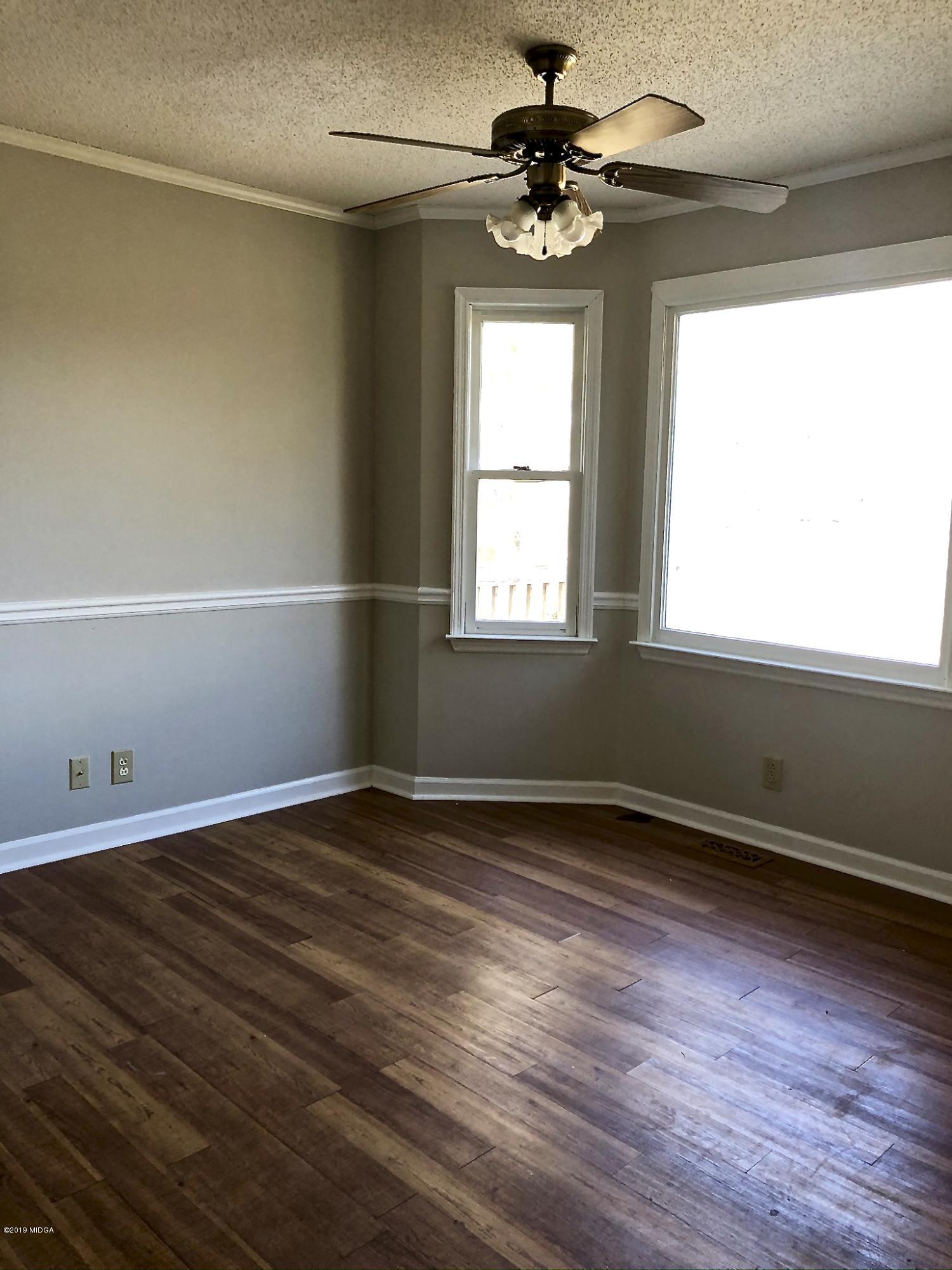 230 J R Boulevard Macon, GA 31220 - Photo 6 of 12 an empty room with wooden floor fan and windows