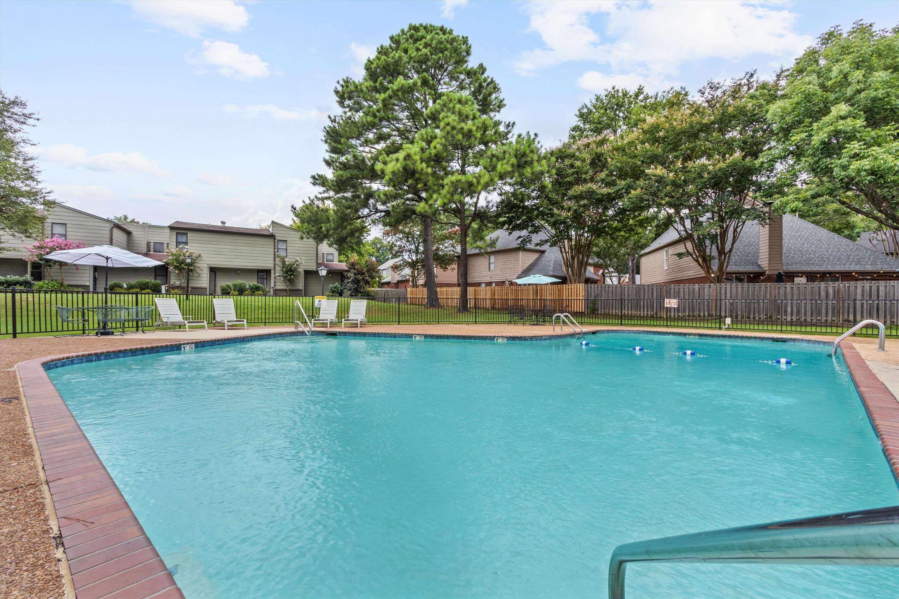 1906 Allenby Road, Unit 16 Germantown, TN 38139 - Photo 27 of 31 Community swimming pool with a brick coping and metal handrails, enclosed by a black metal fence