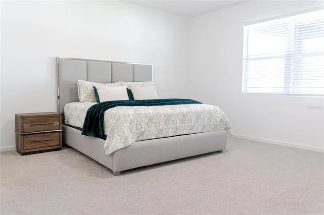 a bed sitting in a bedroom next to a window