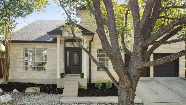 a front view of a house with a tree