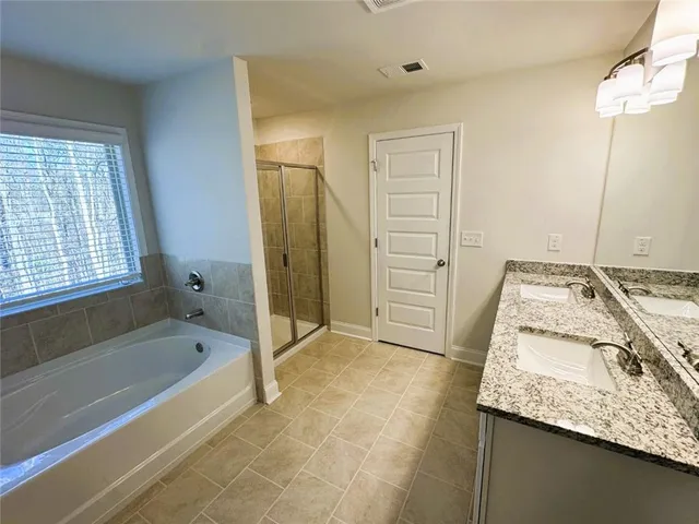 a bathroom with a granite countertop sink a toilet and bathtub