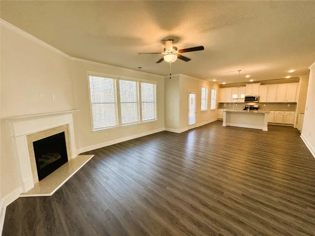 a view of a livingroom with furniture a fireplace wooden floor and chandelier