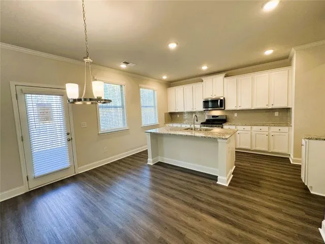 a kitchen with a refrigerator and white cabinets