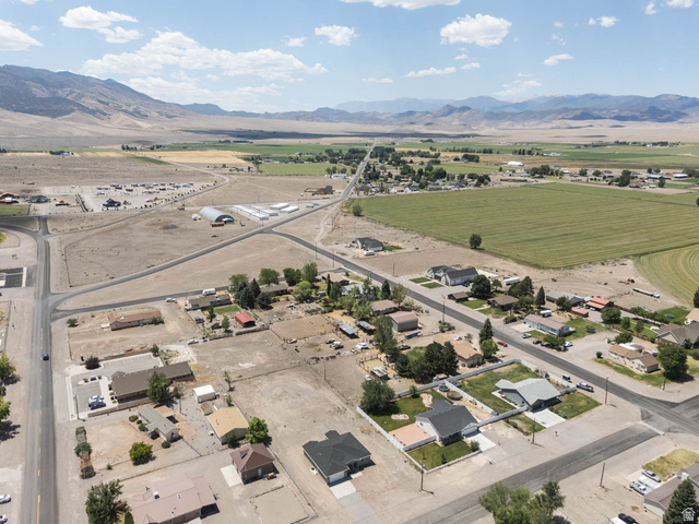 51 West 500 South Monroe, UT 84754 - Photo 40 of 41 Expansive aerial perspective showcasing a neighborhood with varied residential properties, agricultural fields, and mountainous terrain in the distance