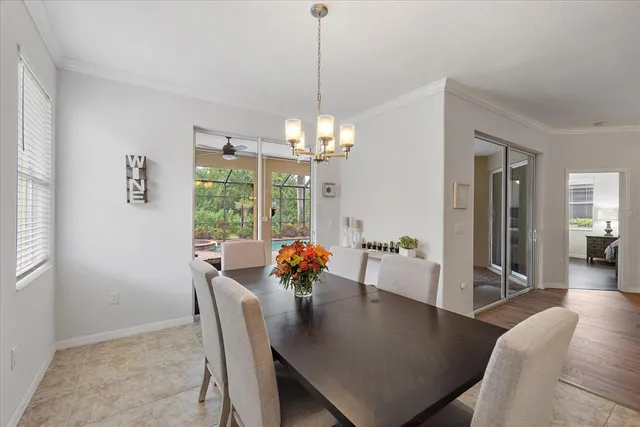 a dining room with furniture a chandelier and wooden floor