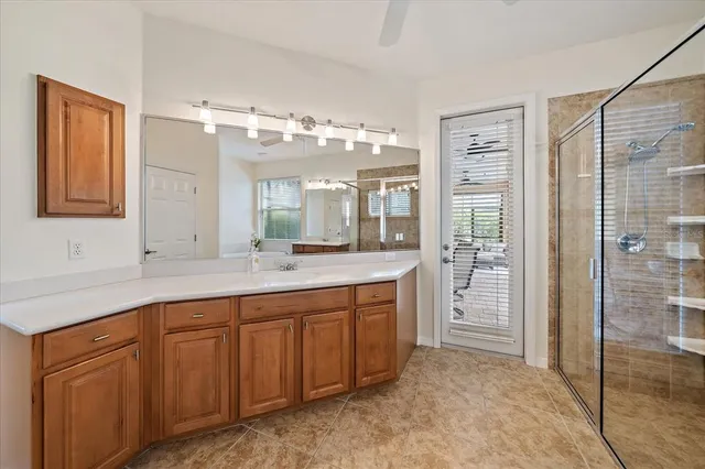 a spacious bathroom with a granite countertop sink mirror and shower