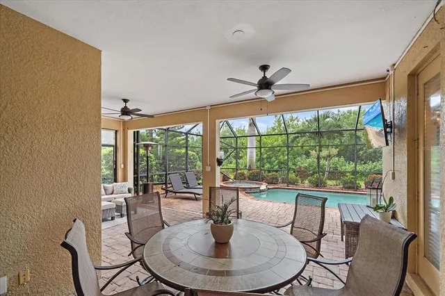 a dining room with furniture a chandelier and glass door