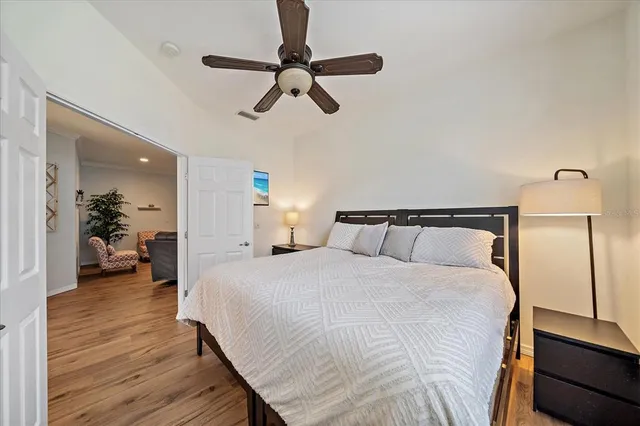 a spacious bedroom with a bed and wooden floor