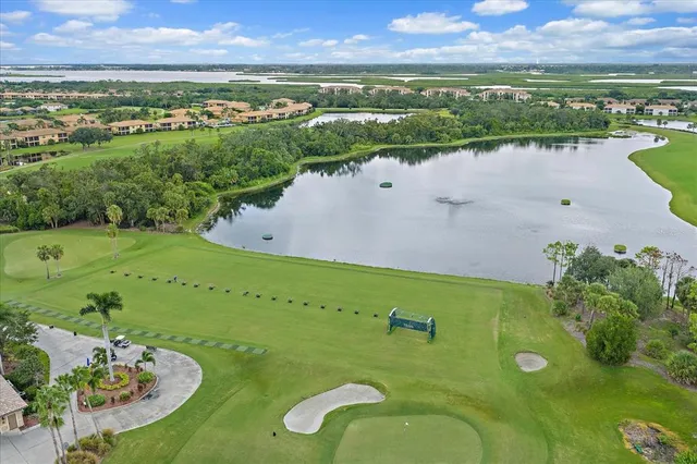 an aerial view of a golf course with a lake view