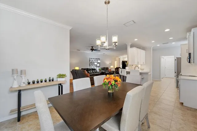 a view of a dining room and livingroom with furniture wooden floor a chandelier