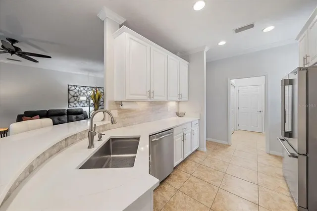a kitchen with stainless steel appliances granite countertop a sink and a refrigerator