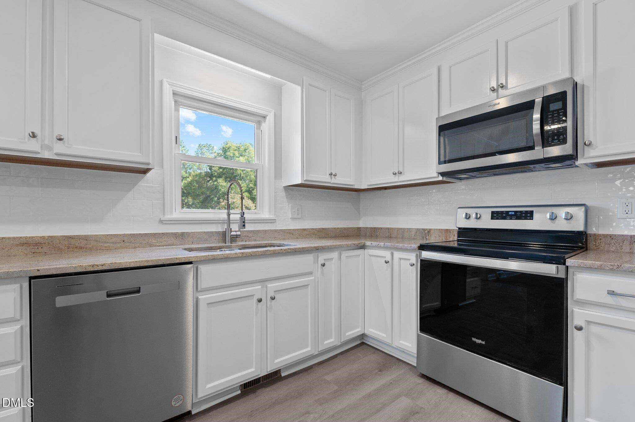 6501 Rock Service Station Road Raleigh, NC 27603 - Photo 28 of 49 a kitchen with stainless steel appliances granite countertop white cabinets a sink and a window