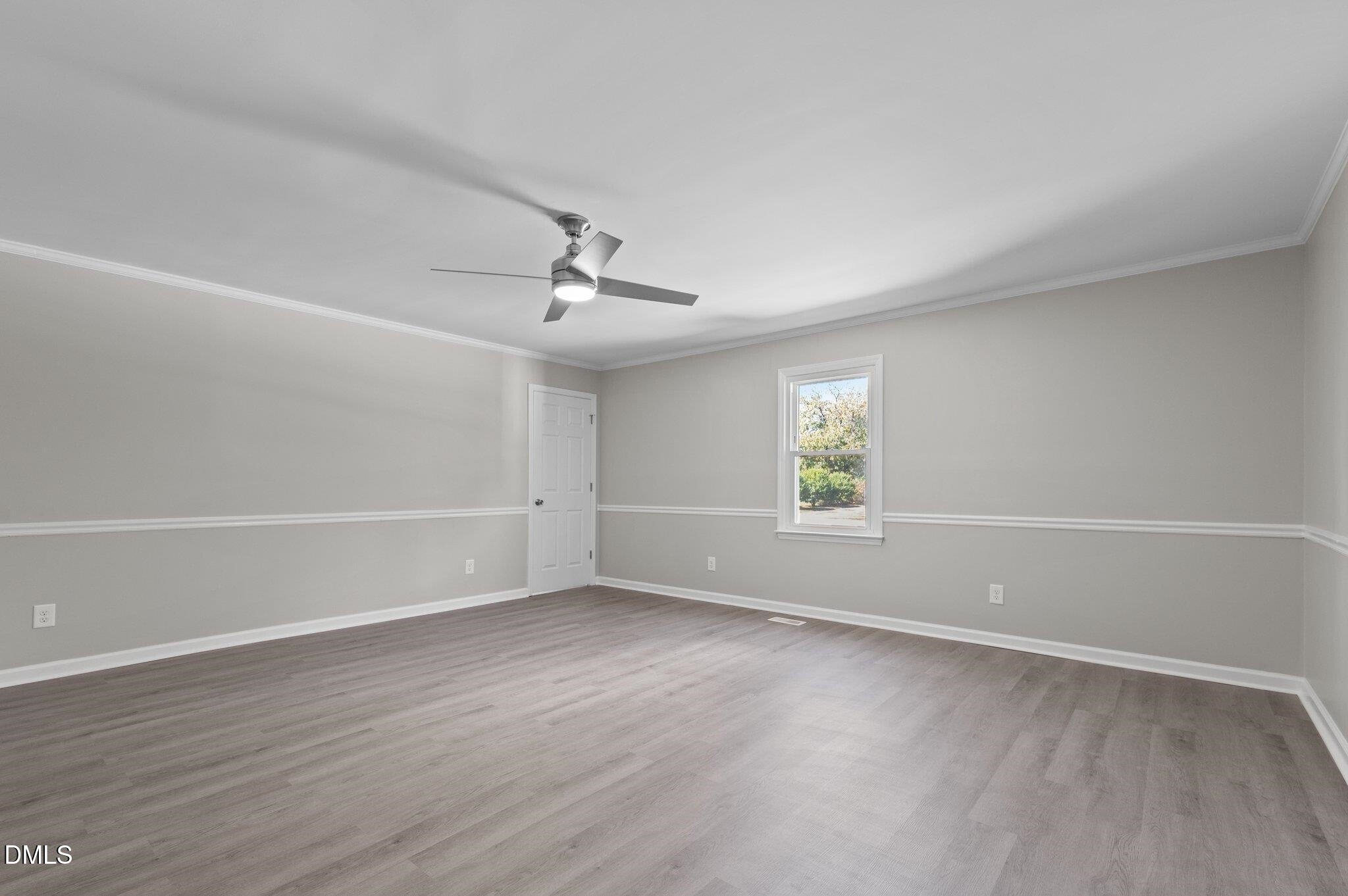 6501 Rock Service Station Road Raleigh, NC 27603 - Photo 34 of 49 an empty room with wooden floor chandelier fan and windows