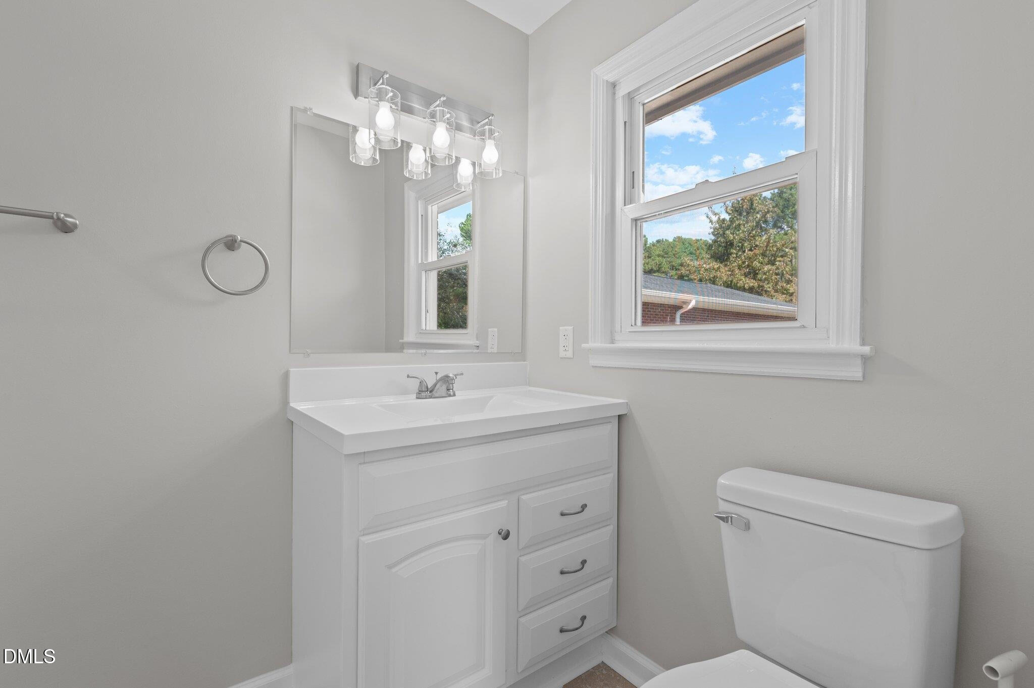 6501 Rock Service Station Road Raleigh, NC 27603 - Photo 42 of 49 a bathroom with a toilet a sink a vanity and mirror