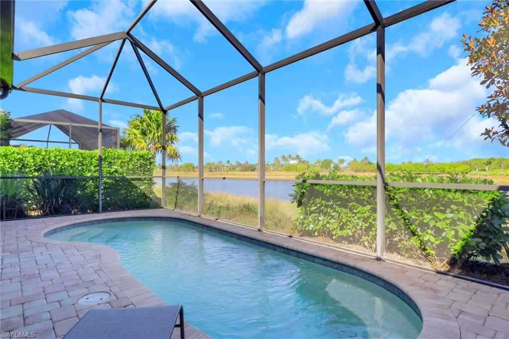 6809 Bequia Way Naples, FL 34113 - Photo 31 of 49 Outdoor pool with a sunroom, glass enclosure, area for grilling, a patio area, and a water view